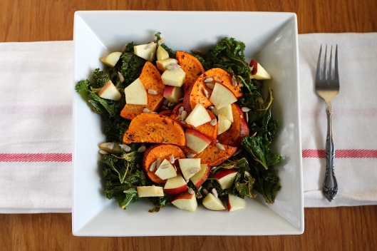 Warm roasted salad with kale, sweet potatoes, apple, and sunflower seeds.